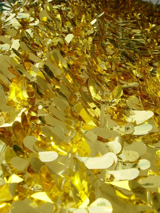 gold foiled pieces of confetti with lots of yellow sparkle on the side