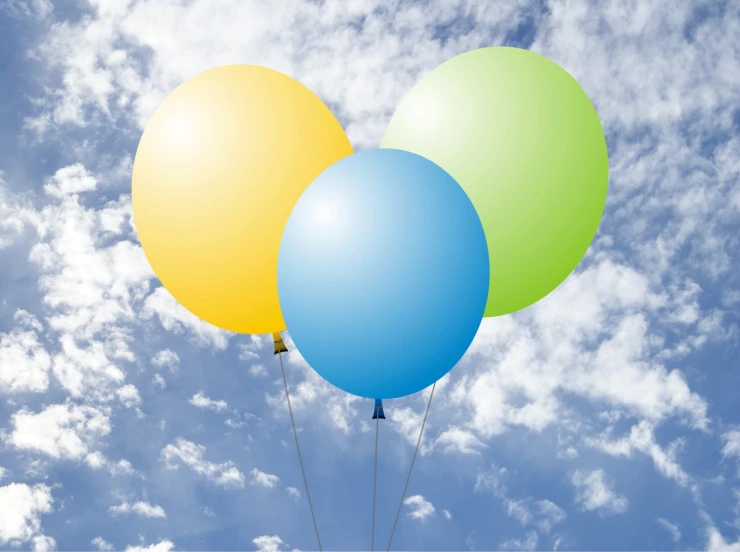 several balloons floating through the air on a cloudy day