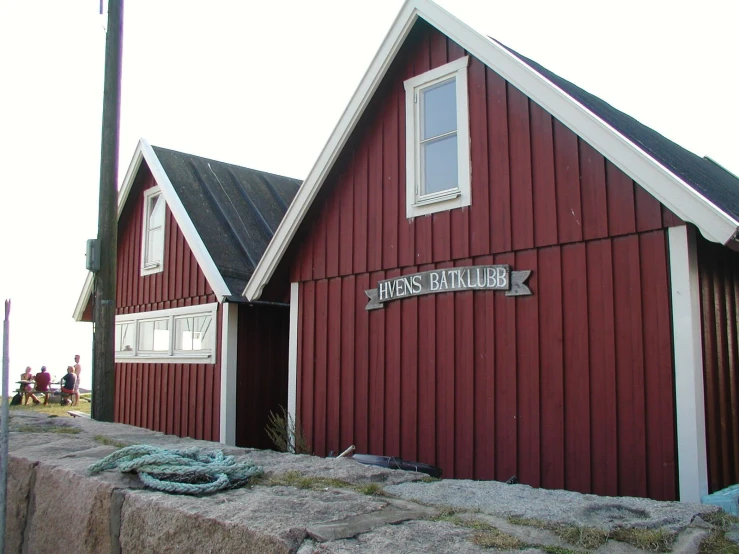 a red building with two story and a wooden sign reading house restaurant