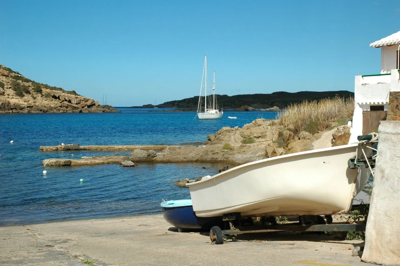 a boat sits on the shore near an inlet