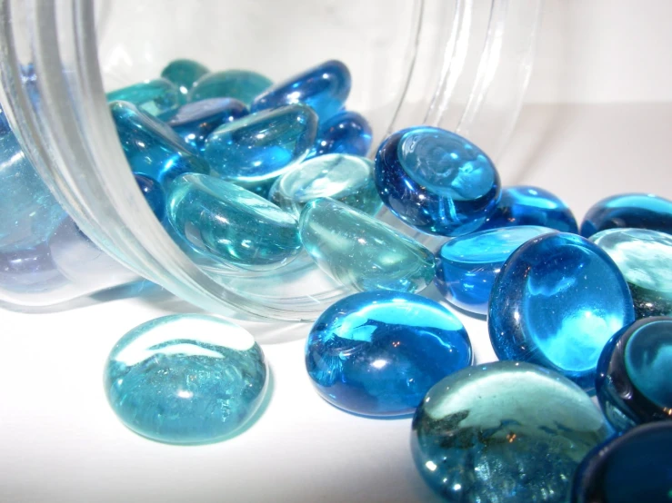 glass marbles are pouring into a jar