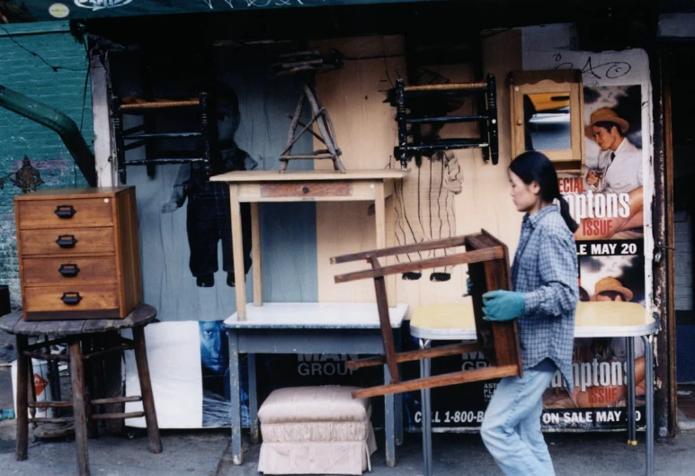 a woman walks in front of several antique furniture and accessories