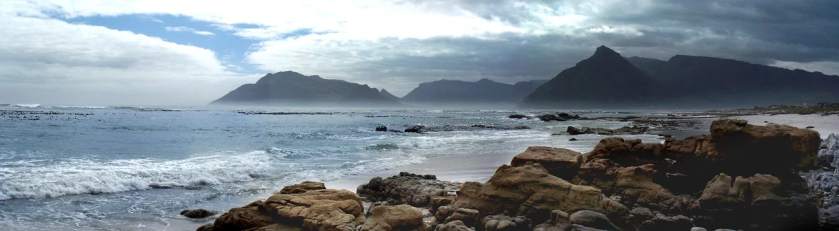 a beach filled with lots of water next to rocky cliffs