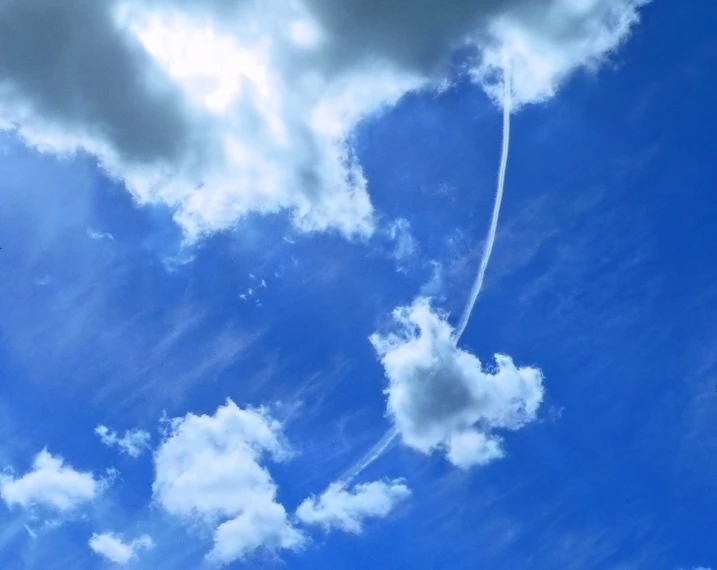 an airplane flying in the sky with clouds