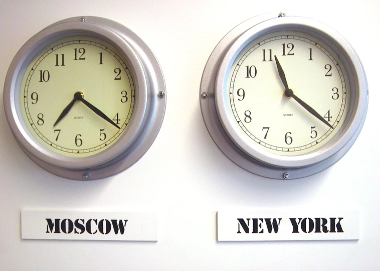 two clocks displaying the times to different cities