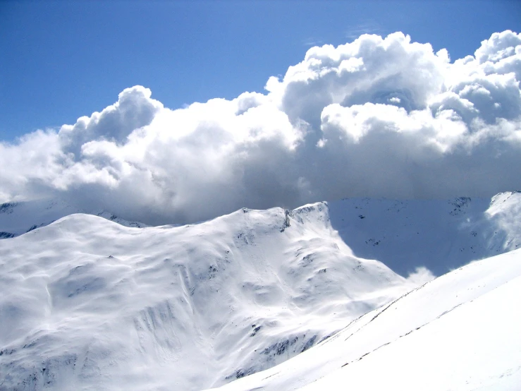 a snow covered mountain under the cloudy sky