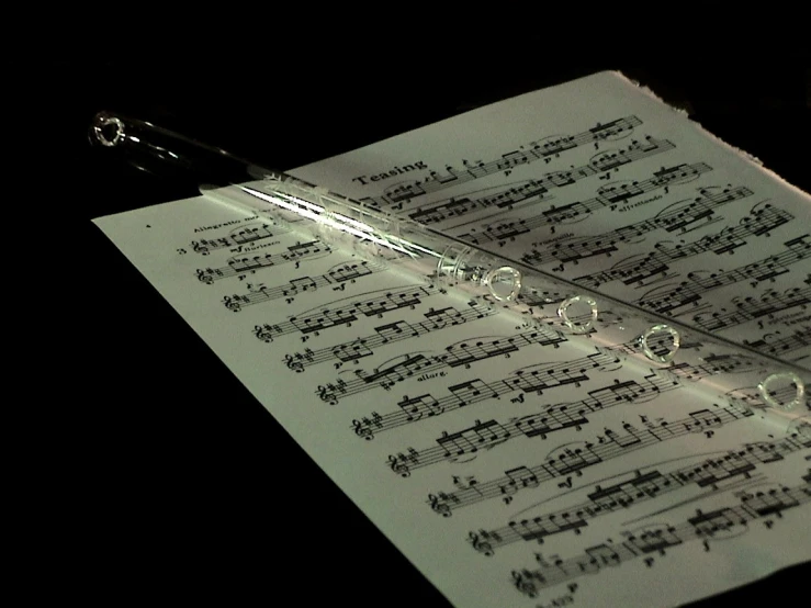 a musical note on a string with sheet music written in white ink