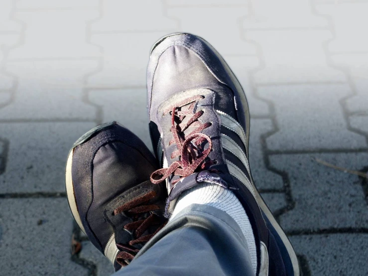 a person's feet in sneakers walking on the ground