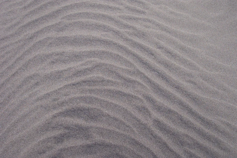 a beach area with sand blowing and other patterns