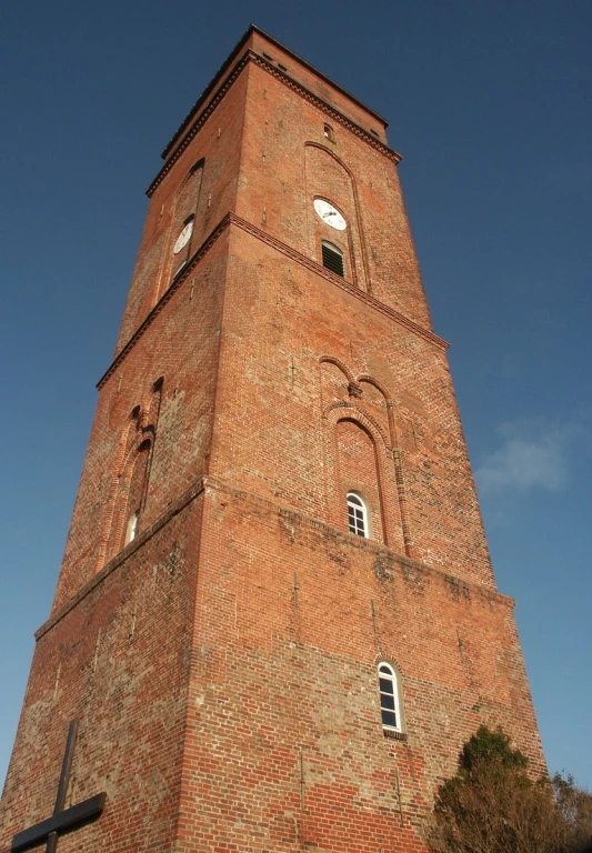 the tall red brick clock tower with white windows