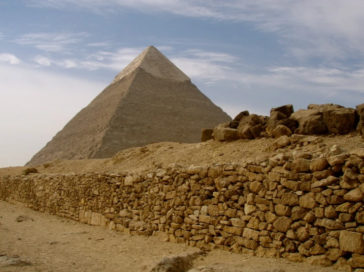 a large stone wall and pyramid near some rocks