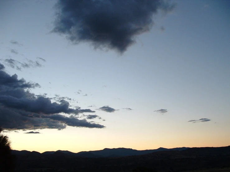 a cloudy view of the mountains with two people walking