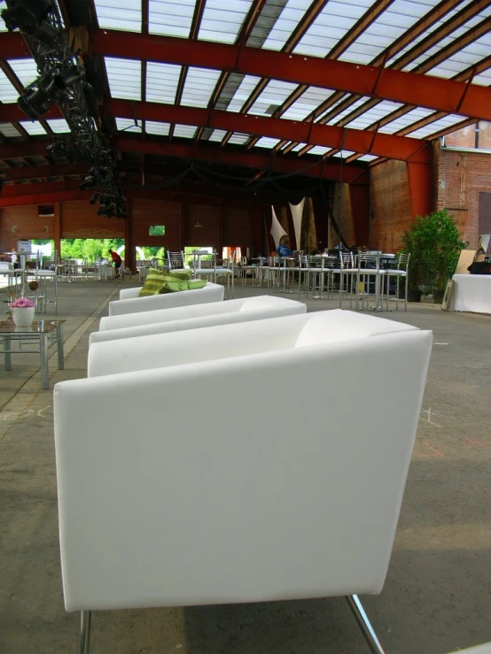 white sofas lined up on metal and glass bases in a building