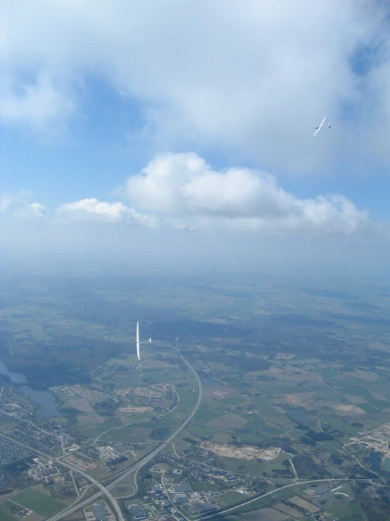 an air plane flying in the air below the clouds