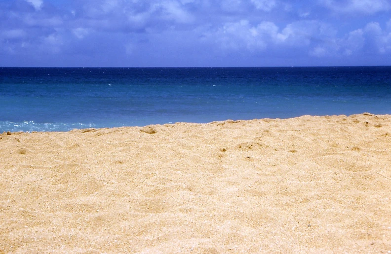 two people standing on the beach with surfboards