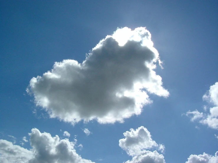 several fluffy white clouds are floating in a blue sky