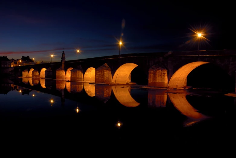 a night time view of a bridge with lights on