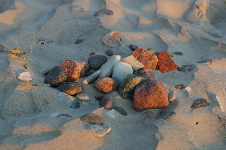 a miniature toy is laying among stones on the beach