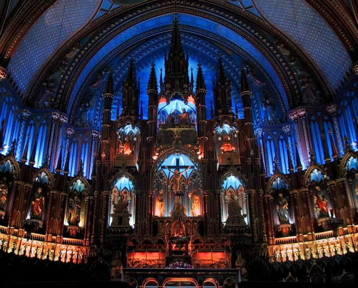 a beautiful cathedral filled with ornate columns, blue lighting, and a clock on the wall