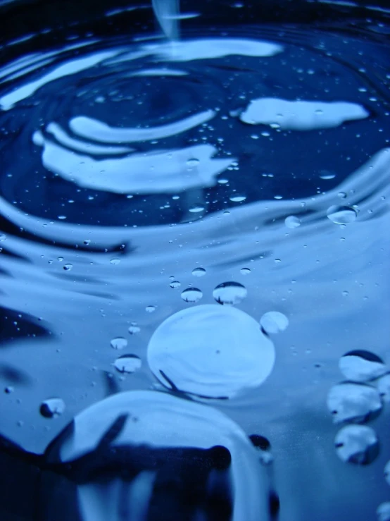 rain drops falling into a dark bowl filled with water