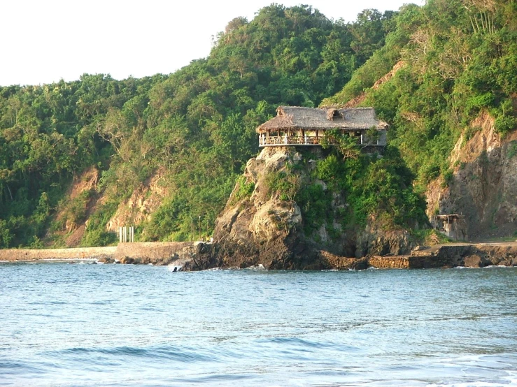 there are houses on top of a cliff in the water