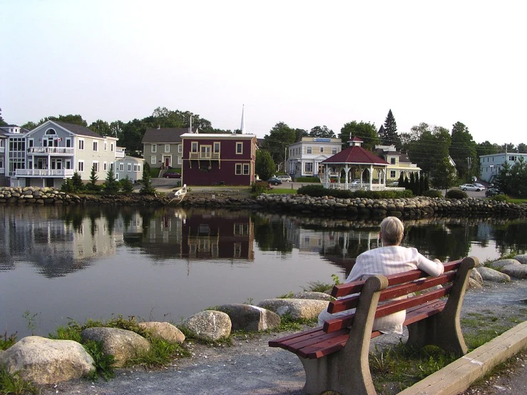 an old woman sitting on top of a wooden bench