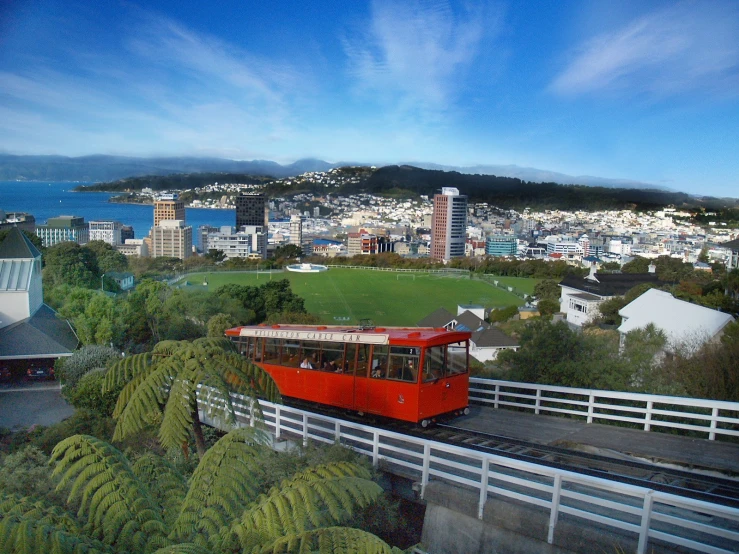 an overhead s of a red train traveling over a bridge