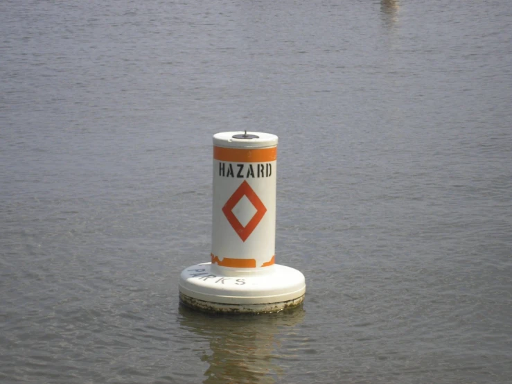 a white buoy floating in some water next to other buoys