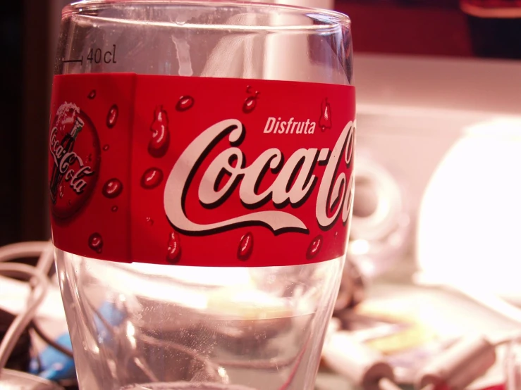 a close up of a coca cola can in a glass
