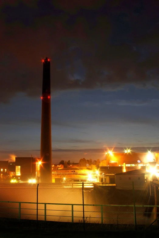 a large metal chimney standing over a small fence