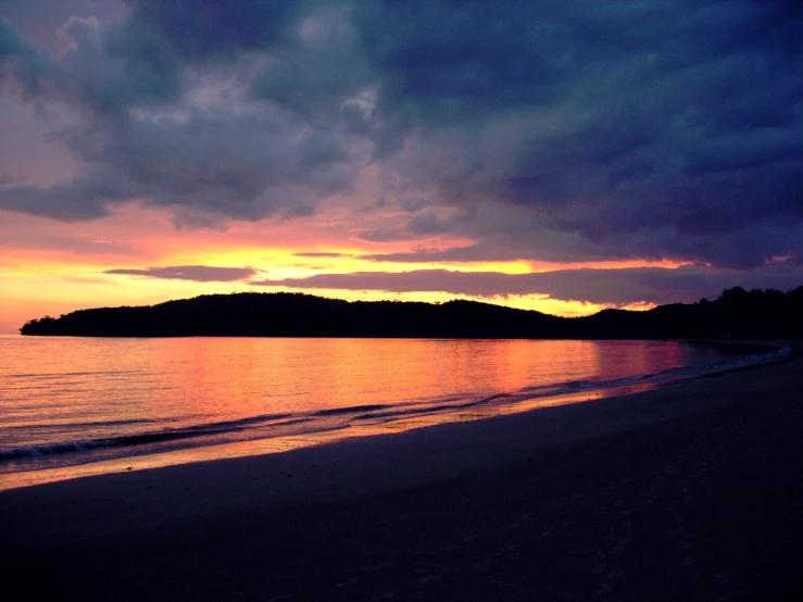 dark clouds are shining and the beach water is quiet