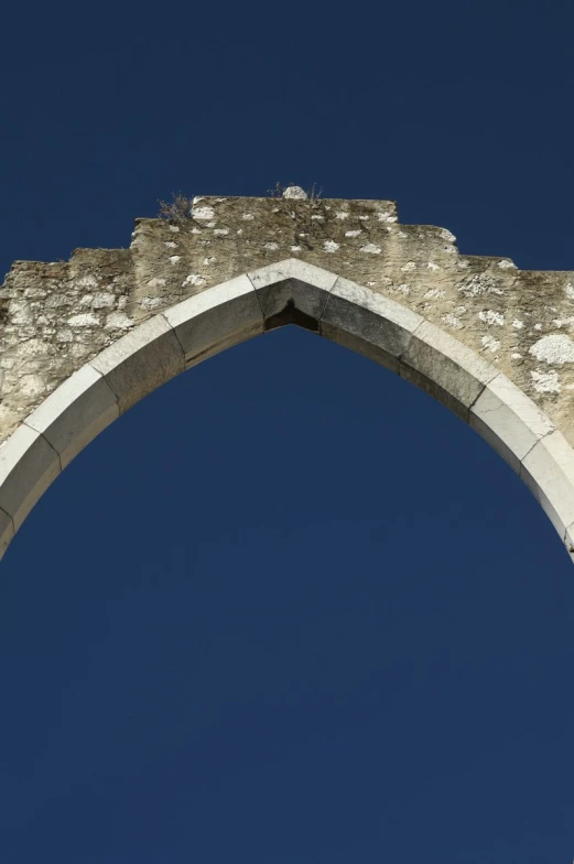 a stone arch with sky background looking up