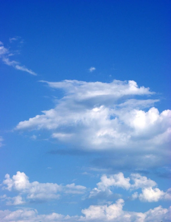 a boat on a large body of water under a cloudy blue sky