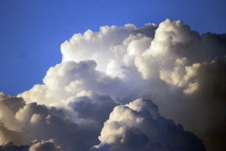 the sky is full of large clouds and birds flying