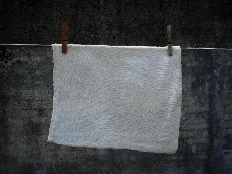 an unoned dish towel hanging on a clothes line
