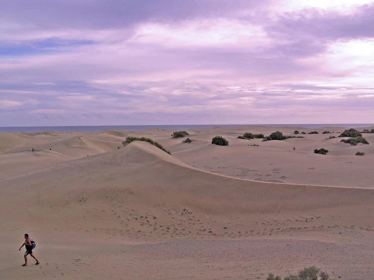 an person standing on top of a sandy hill