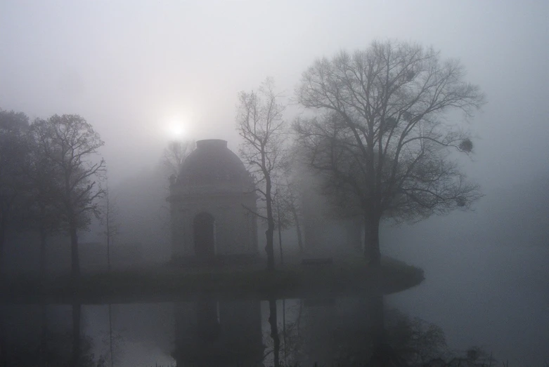 there is a building on the lake during sunrise