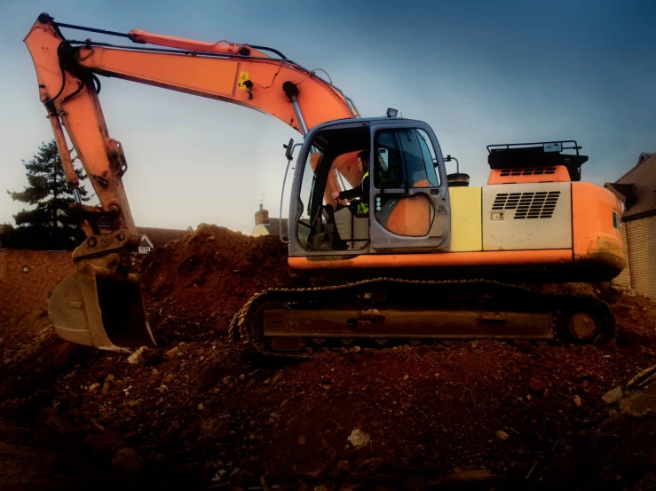 a construction worker sits in the back of an excavator