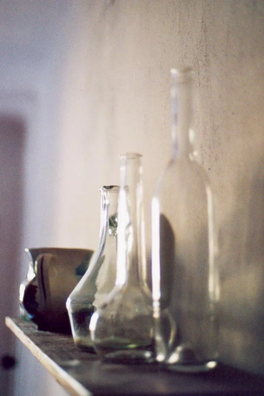 a shelf filled with glass bottles and dishes