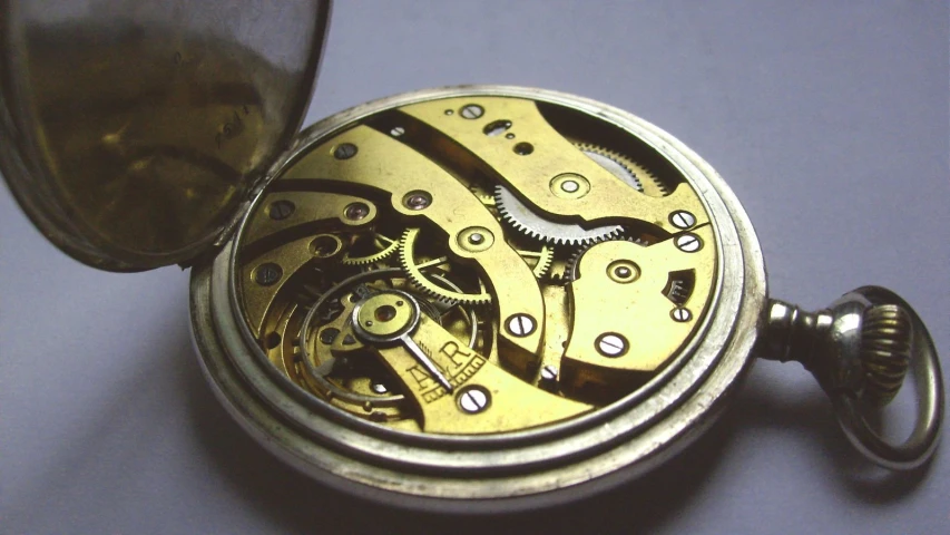 an old open gold pocket watch with a watch movement