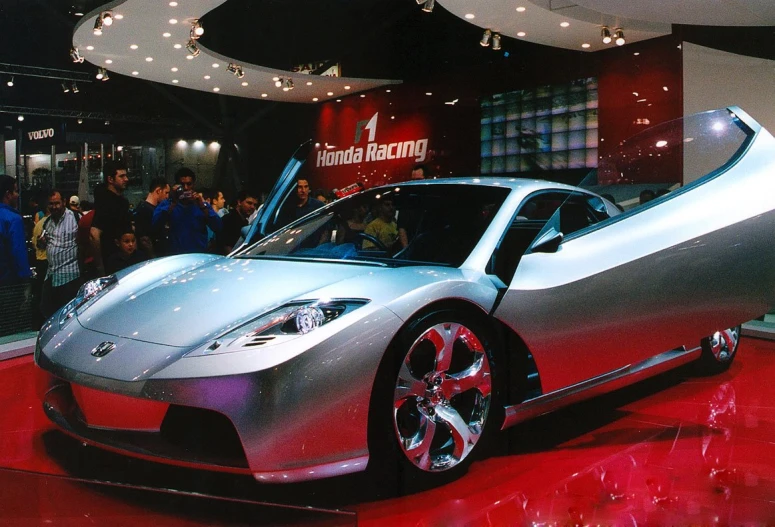 a silver sports car is on display at a show