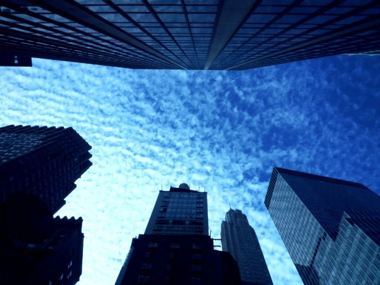 a group of skyscrs are silhouetted against the blue sky