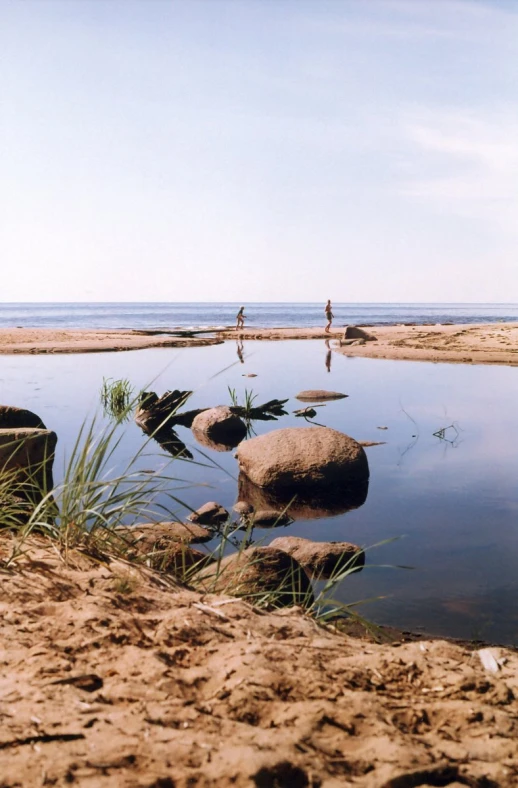 people walking along the shore of a body of water