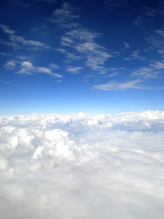 an airplane flies overhead while above the clouds