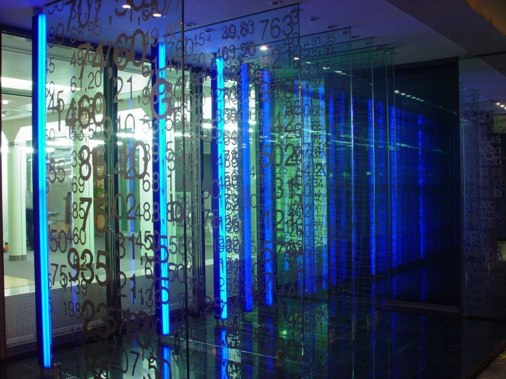 a room with rows of blue lights and metal screens on the wall