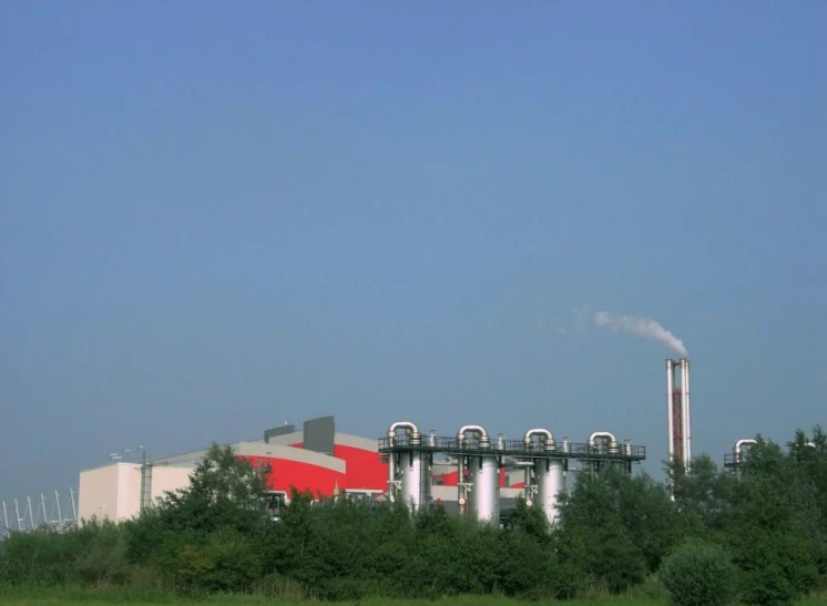 a large factory building with chimneys and air conditioning towers