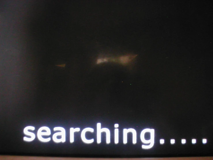 a sign lit up in white text reading searching