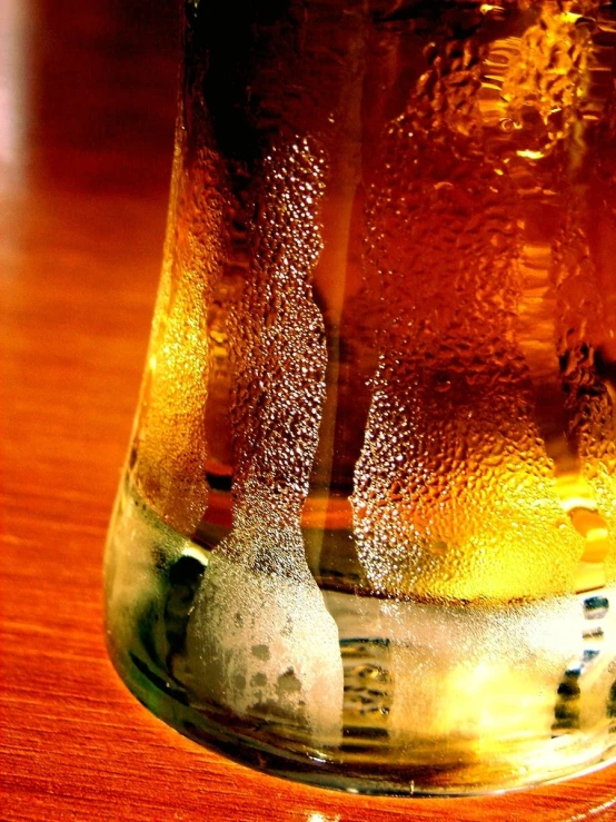 a glass with liquid sitting on top of a table