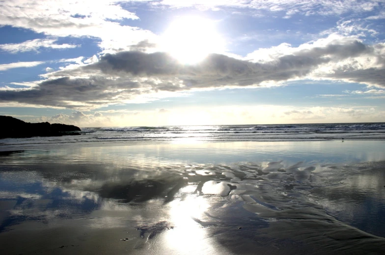 a cloudy sky over the ocean with water and waves