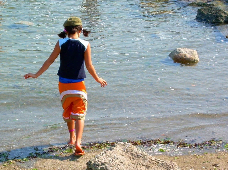 a girl standing by the edge of a body of water